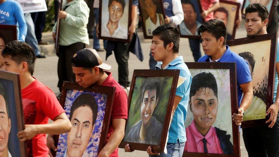 Relatives and activists holding up portraits of the 43 missing students