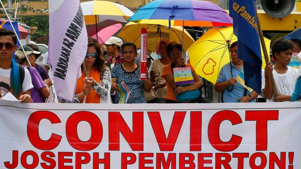 Protesters display placards during a rally near the Presidential Palace in Manila to await the verdict for U.S. Marine Pfc. Joseph Scott Pemberton who is accused in the killing of Filipino transgender Jennifer Laude, Tuesday, Dec. 1, 2015 in the Philippines