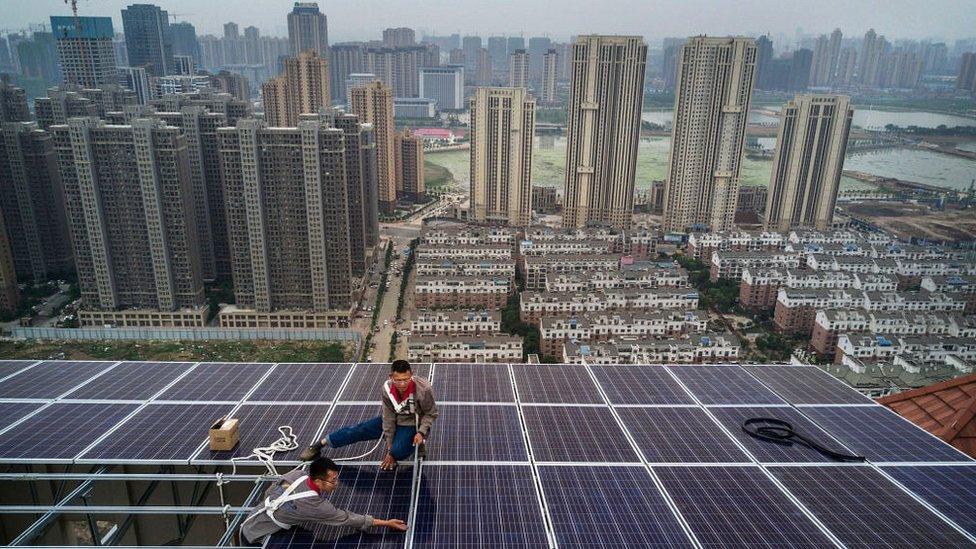 Men work on a solar panel project in Wuhan, China.