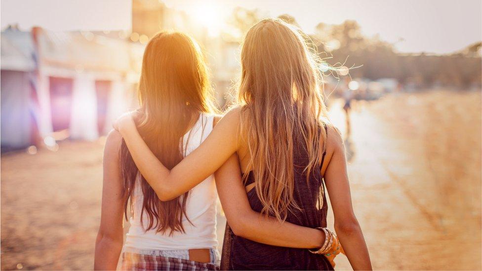 Two women in the sunshine at a festival