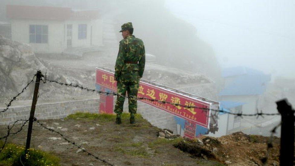 A Chinese soldier stands guard on the Chinese side of the ancient Nathu La border crossing between India and China in 2008