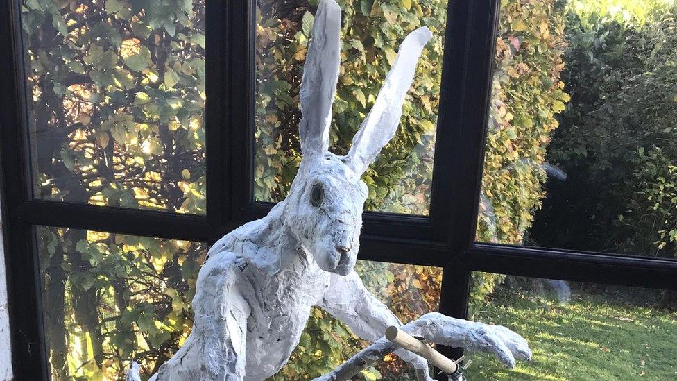 Sculpture of a hare on a child's scooter