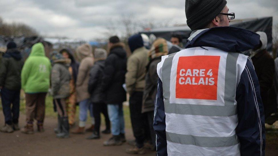 A general view of daily life in the Jungle refugee camp in Calais, France, with a worker wearing a Care4Calais top.