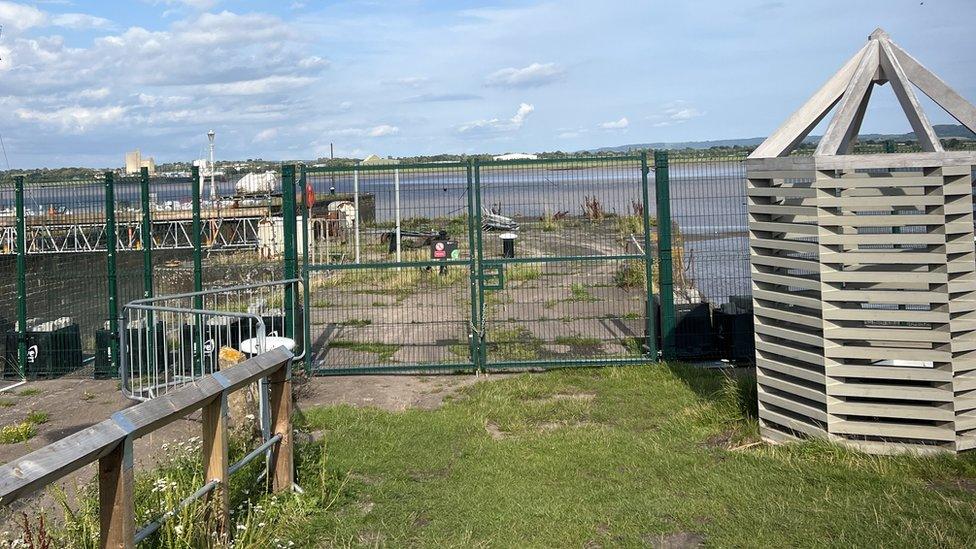 Green metal fencing in front of a pier