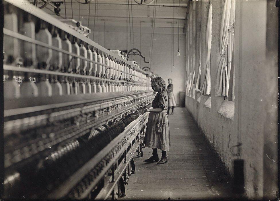 A small girl working at a mill.