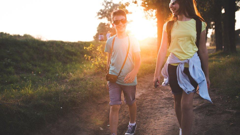 girl and boy walk outside socially-distanced