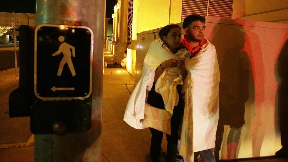 man and woman with a sheet around them standing on the street