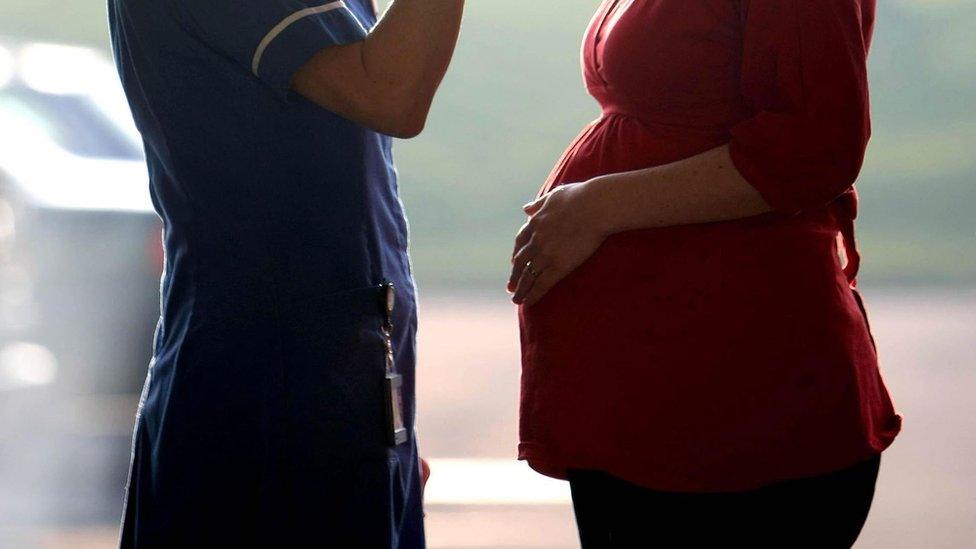 Pregnant woman speaking to healthcare professional