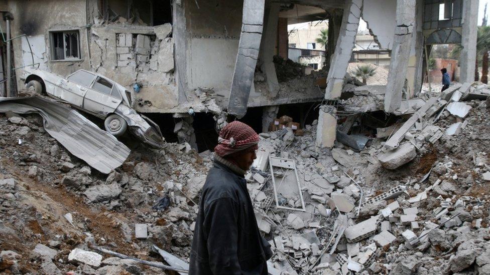 A man is seen near rubble of damaged buildings after an airstrike on the Eastern Ghouta town of Misraba, Syria, January 4, 2018.