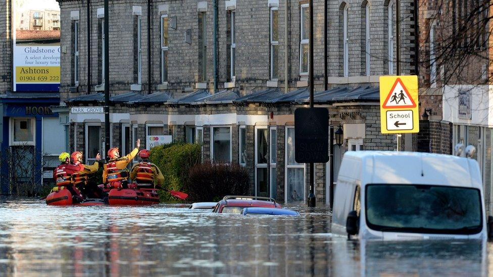 Members of a Mountain Rescue team check on properties after the River Foss and Ouse burst their banks, in York