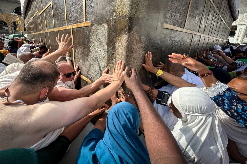 Muslim worshippers touch the Kaaba, Islam's holiest shrine, at the Grand Mosque in Saudi Arabia's holy city of Mecca