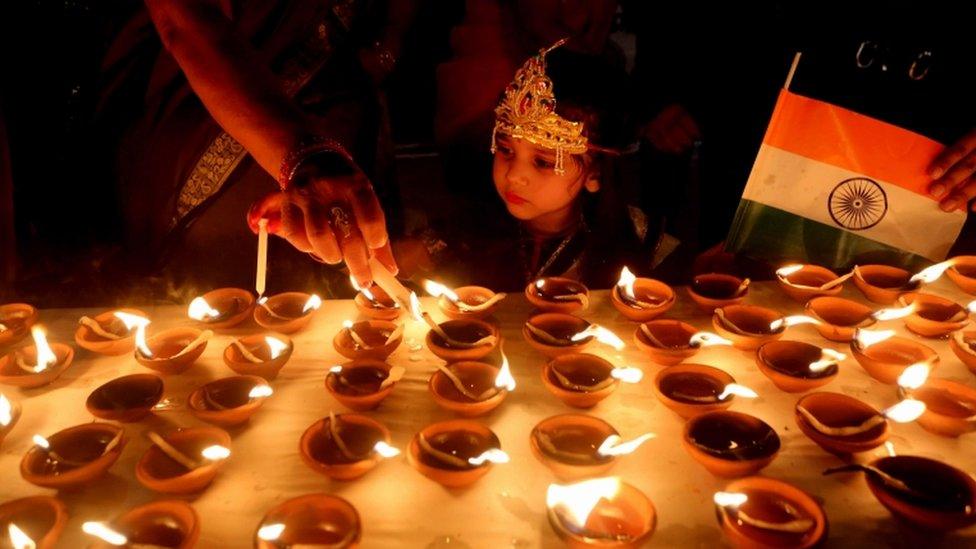 A small child looks at Diwali candles at a temple in Bhopal, India