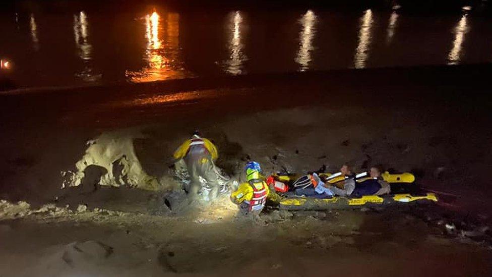 The man and woman being rescued from the mud