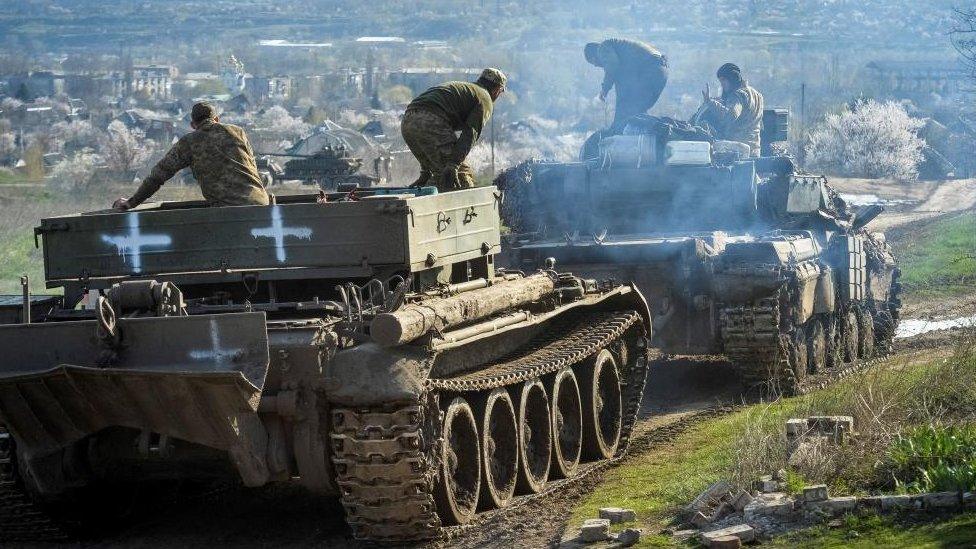 Ukrainian service members ride tanks