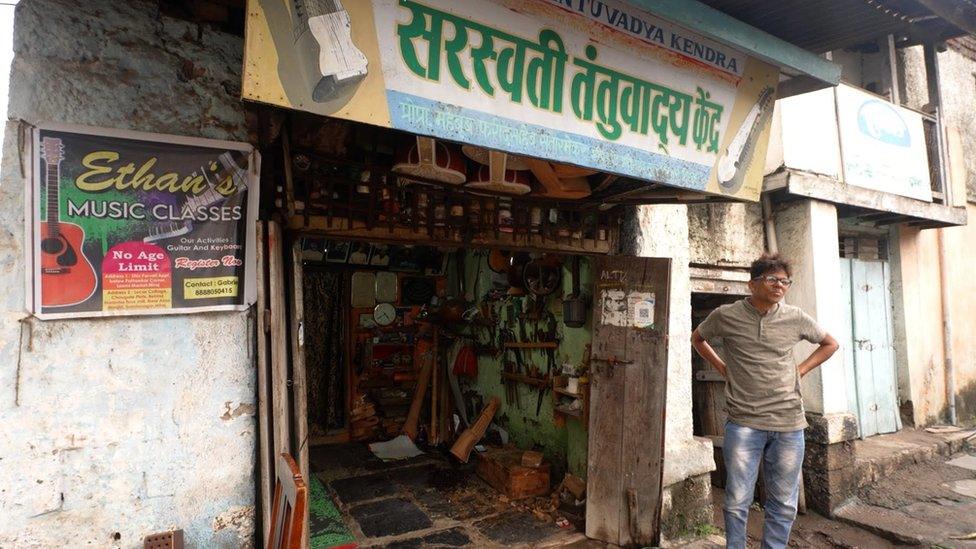 An artisan stands outside his shop in Miraj