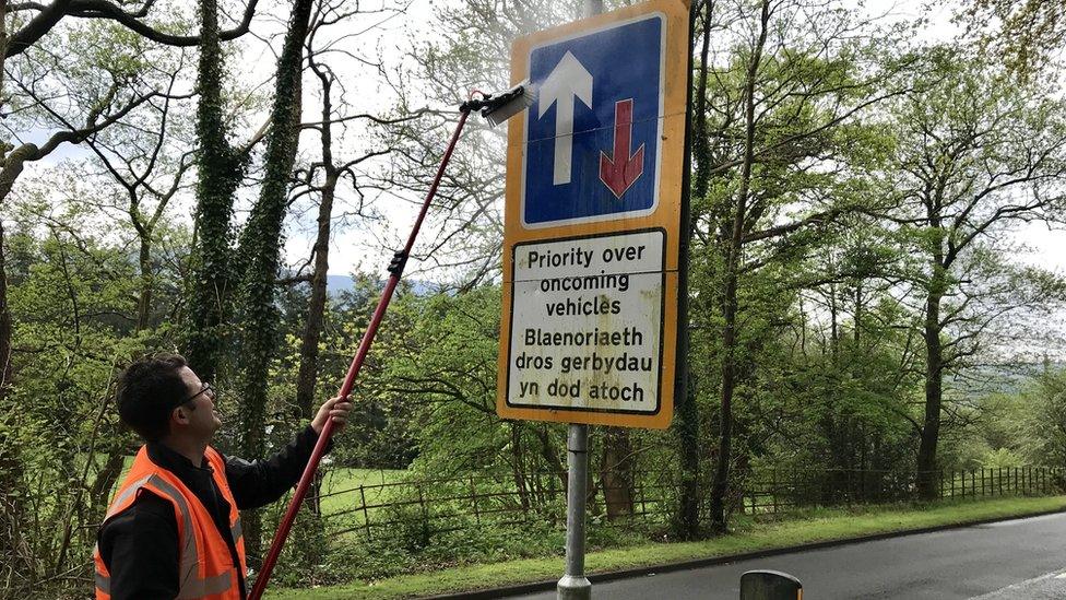 Kieran Benson cleaning the sign