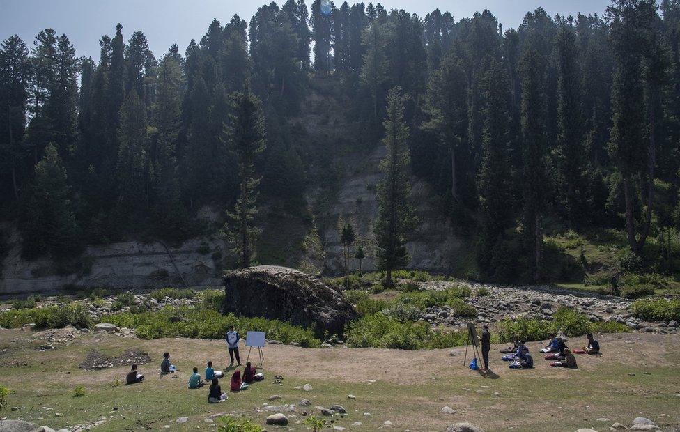 Outdoor classes with hills dotted with trees as backdrop.