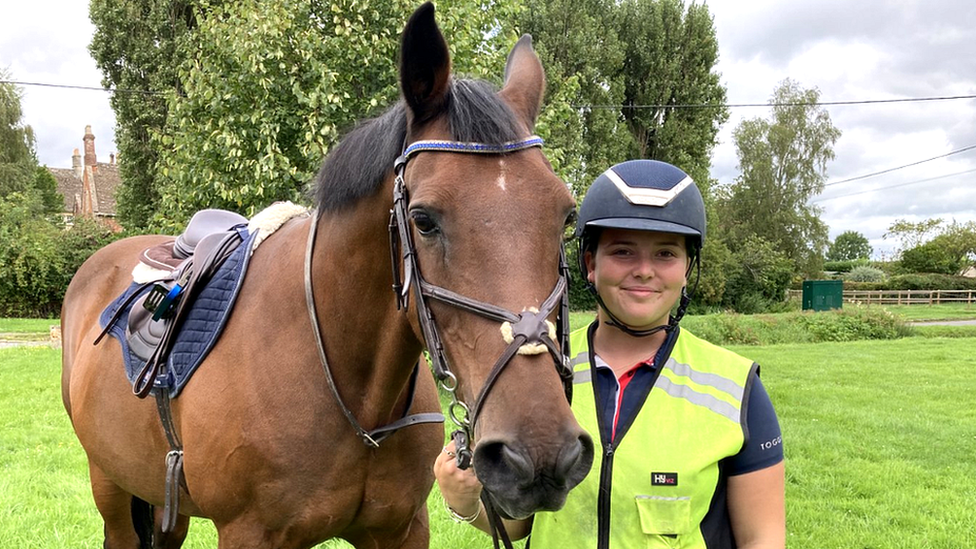 Horse rider standing next to horse