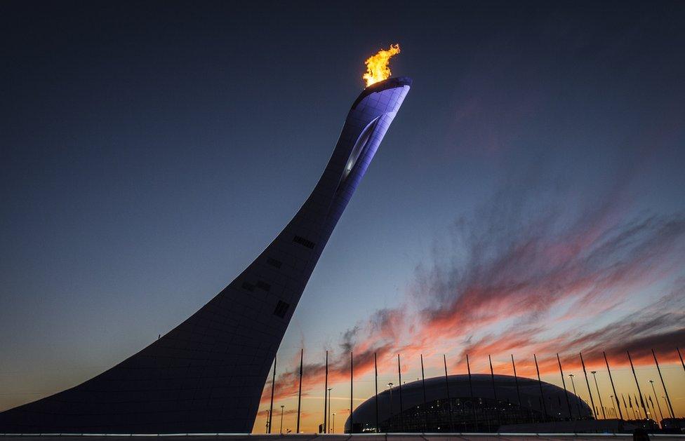 The Olympic Cauldron and flame at sunset.