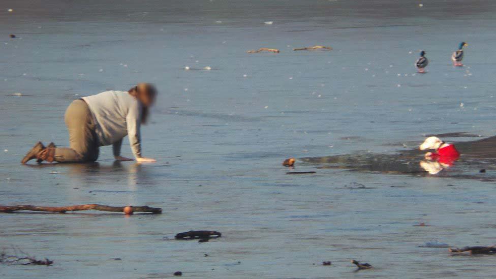 Woman crawls on ice to rescue dog