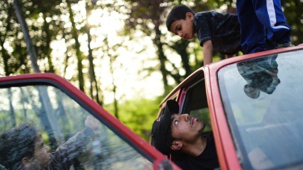 Boys play in a car at the makeshift camp on the Greek-Macedonian border near the Greek village of Idomeni,(05 April 2016)