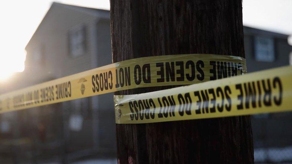 Police tape around a tree near a house in the US