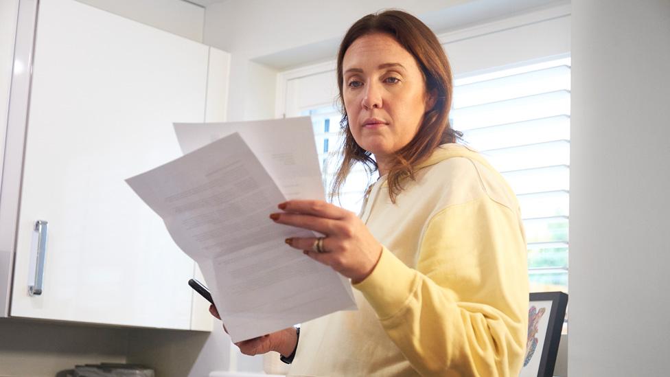 Woman looking at bills at home