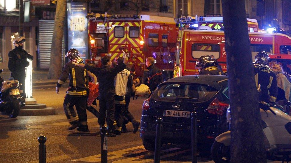 Medics move a wounded man near the Boulevard des Filles-du-Calvaire after an attack November 13, 2015 in Paris