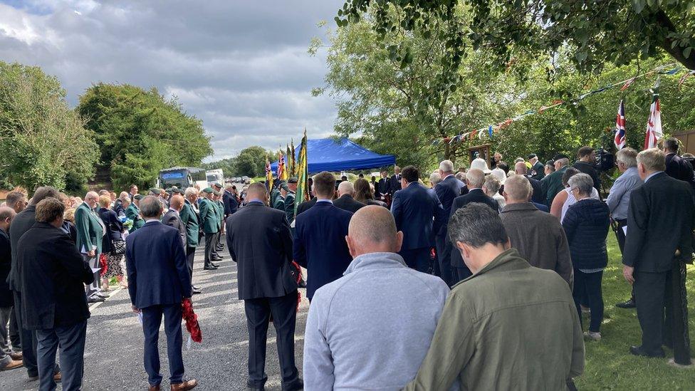 Survivors and families gather at the roadside in Ballygawley