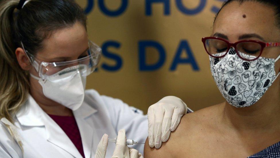 A nurse administers China's Sinovac vaccine to a volunteer at the Sao Lucas Hospital of the Pontifical Catholic University of Rio Grande do Sul (PUCRS), in Brazil, 8 August, 2020.