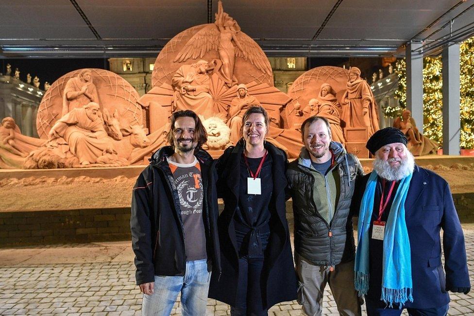 Sand sculptors Radovan Zivny, Susanne Ruseler, Ilya Filimontsev and Rich Varano pose in front of the nativity scene as the artwork is inaugurated at St Peter's Square in Vatican City, 7 December 2018