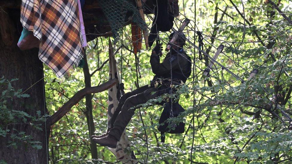 A German elite police unit member climbs a tree