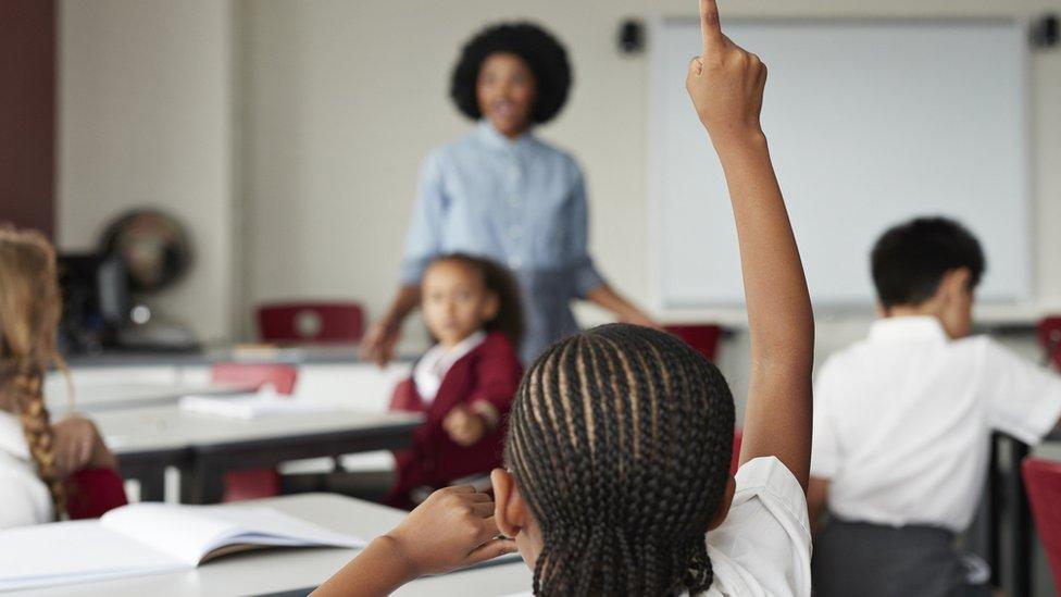 Back of child's head with hand up