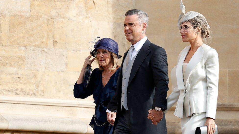 British singer-songwriter Robbie Williams arrives with his wife US actress Ayda Field and her mother Gwen to attend the wedding