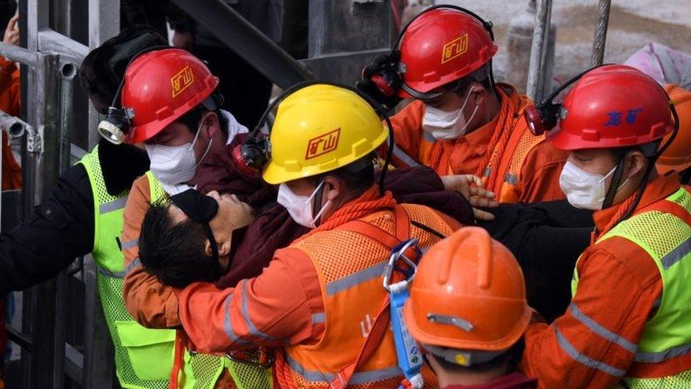 A picture released by Xinhua News Agency shows a trapped miner being lifted from a gold mine in Qixia City, east China's Shandong Province, 24 January 2021.