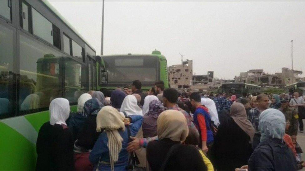 Coaches laid on by the Syrian government bring residents back to al-Qaryatain