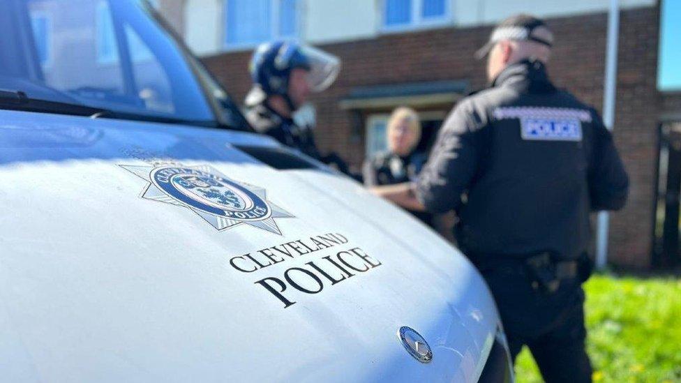 Stock image of a Cleveland Police van with officers talking in the background