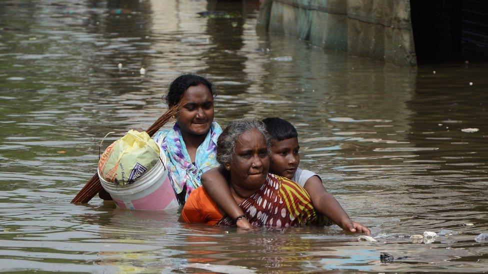 Chennai residents walk through floodwaters