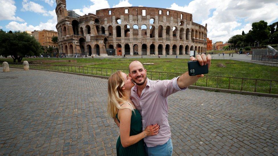 A couple take a picture outside the Colosseum