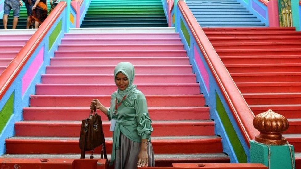 A girl poses in front of the staircase leading to the Batu Caves temple complex in Kuala Lumpur