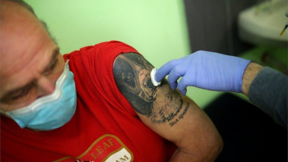 A man sits after receiving a dose of AstraZeneca's coronavirus disease (COVID-19) vaccine administered by a medical personnel from a mobile unit in the village of Ogden, Bulgaria, 25 February 2021.