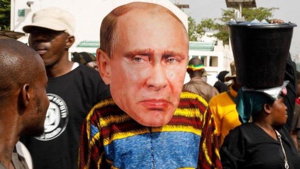 A supporter of Malian Interim President wears a face mask of the President of Russia, Vladimir Putin, during a pro-Junta and pro-Russia rally in Bamako on May 13, 2022