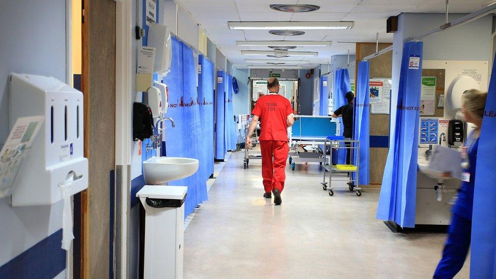 File photo of doctors and staff moving around a corridor in an NHS hospital.