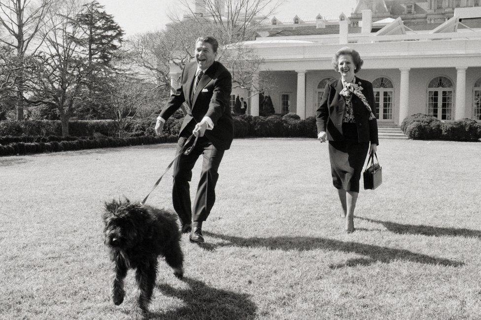 President Reagan and Prime Minister Margaret Thatcher walk a dog together