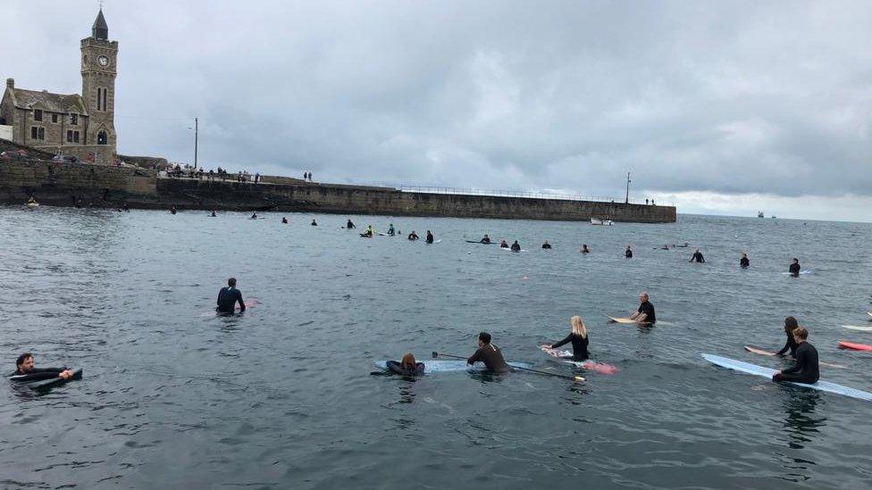 Paddle-boarders floating on the water in a circular formation