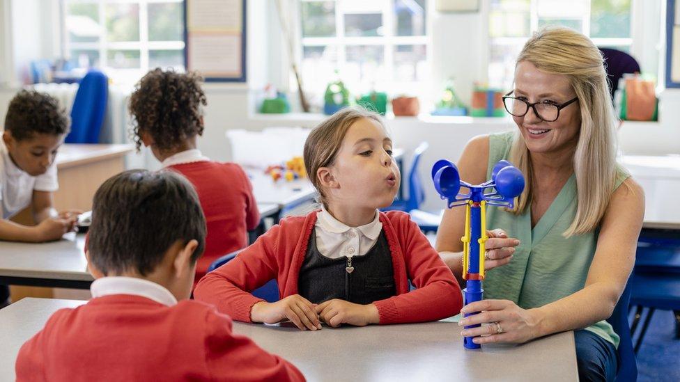 A child and a teacher in a school classroom