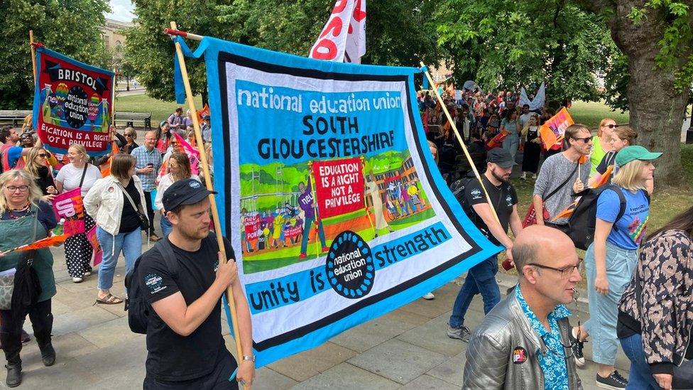 People marching holding colourful NEU banners for Bristol and South Gloucestershire