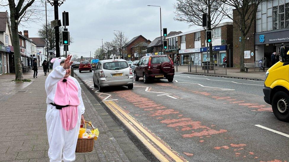 Maria Draper dressed as a bunny waving to people in the street