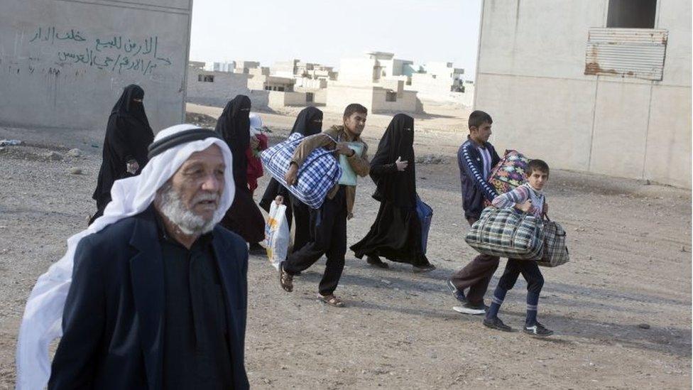 People who were displaced from their homes by fighting between Iraqi forces and Islamic State militants return to their neighbourhood in Kukjali, an eastern district of Mosul, Iraq, on 2 November