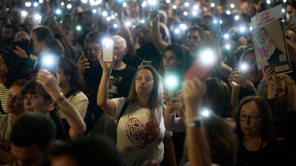 Protesters holding their mobile phone flashlights aloft